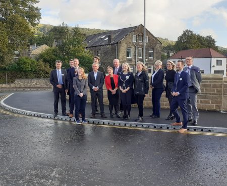 Councillors, the CEO of Calderdale Council, the Mayor of West Yorkshire and other dignitaries stand outside on the new bridge at the Mytholmroyd Flood Alleviation Scheme open event.