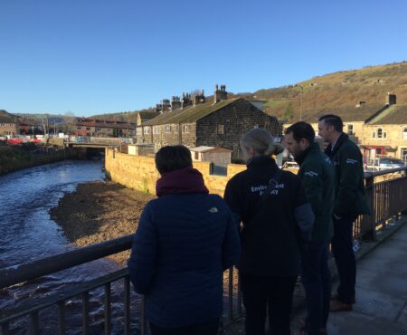 Flood wardens and Environment Agency staff stand on the new bridge at Mytholmoryd built as part of the flood defences.