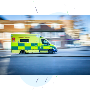 Ambulance with sirens on, driving at speed to the emergency.