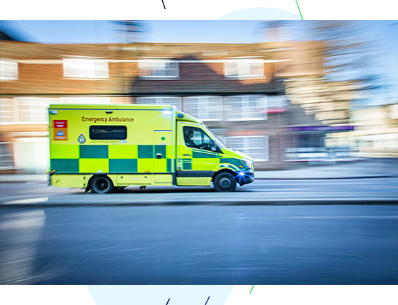 Ambulance with sirens on, driving at speed to the emergency.
