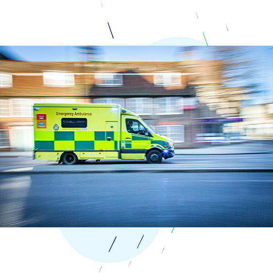 Ambulance with sirens on, driving at speed to the emergency.