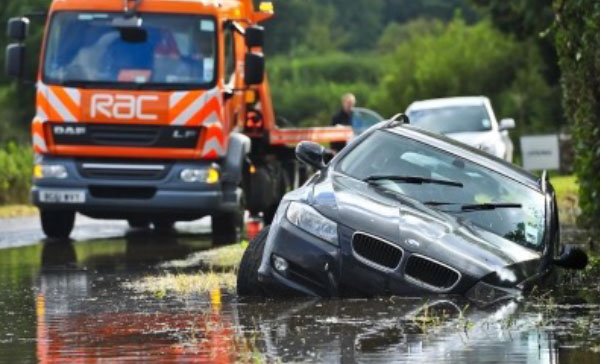 Breakdown company rescuing a car submerged in flood water.