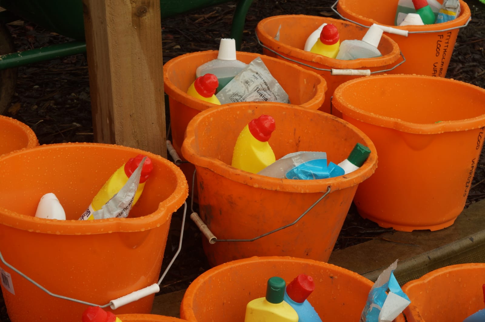 Orange buckets filled with cleaning equipment.