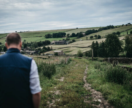 A man walking down a farmers track in rural Calderdale.