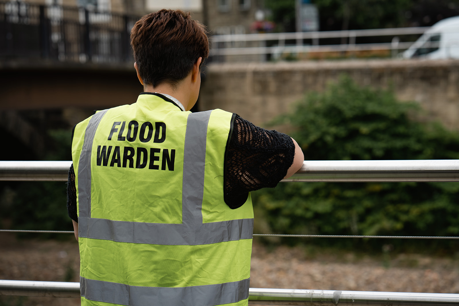 Woman wearing high vis jacket with the words 'Flood Warden' on the back