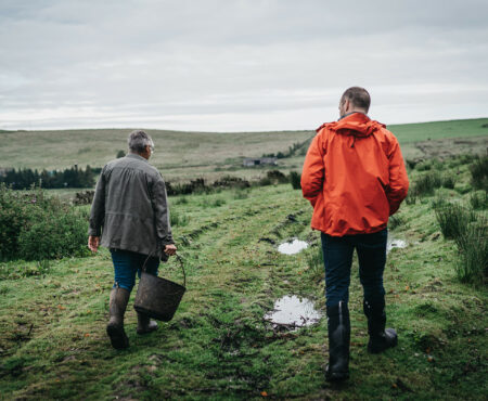 Landowner and natural flood management officer walk through fields together
