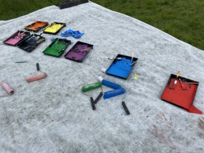 A mix of painting pots, including red, blue, purple, green, black, pink and yellow. 