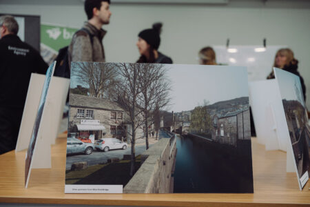 Hebden Bridge drop in event. Display boards of past flooding were on show and a crowd gathers around the display boards.