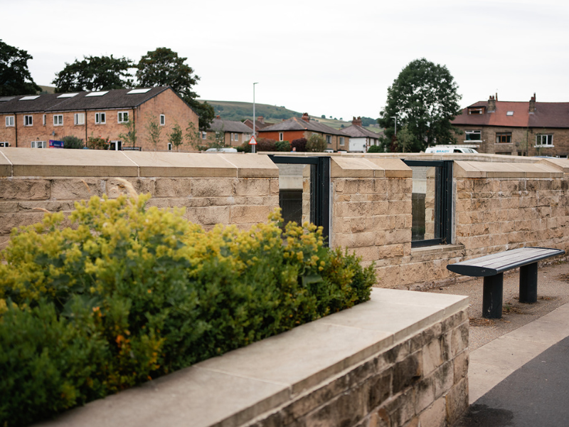 Mytholmroyd Flood Alleviation Scheme. Newly constructed wall with windows at the side of the River Calder.