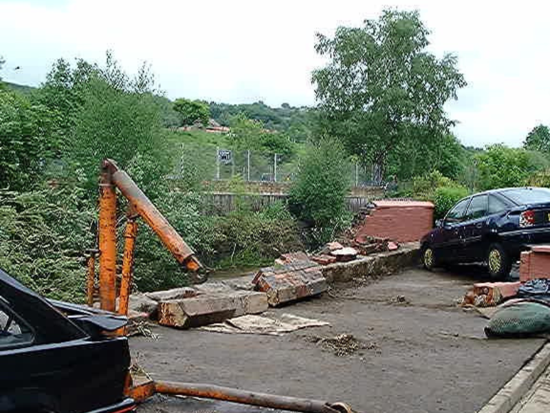 Aftermath of a flash flood:. A car lies overturned on its side amid debris, highlighting the force and suddenness of the disaster.