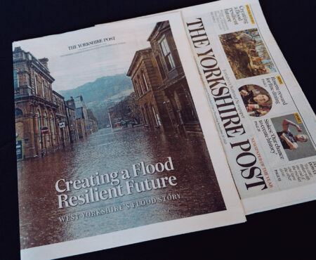 Front cover of a paper copy of the Yorkshire Post newspaper with a supplement laid over the top. The supplement has the headline: Creating a flood resilient future - West Yorkshire's Flood Story