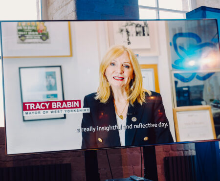 A large television screen at the West Yorkshire Flood Summit with Tracy Brabin, Mayor of West Yorkshire on.