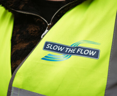 Close up of the Slow the Flow logo on a high vis jacket