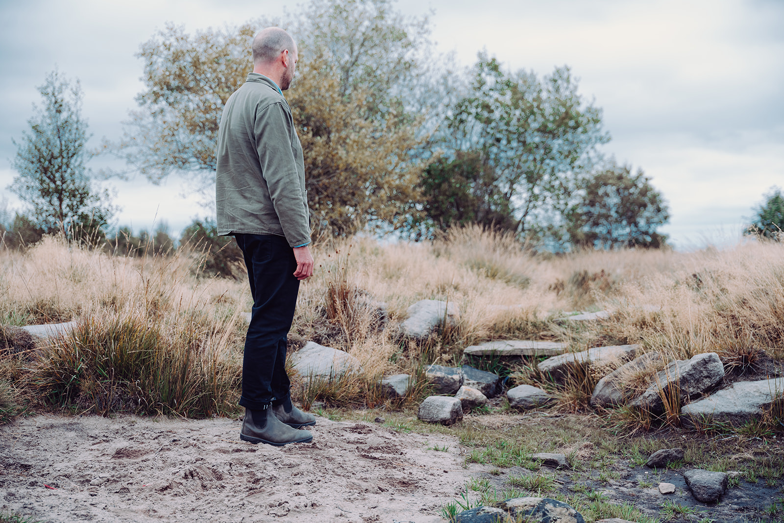 A Calderdale Council NFM officer inspects a rock leaky dam nestled in the wild grass of Norland Moor.