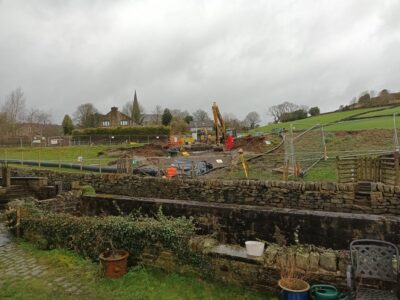 Construction work at Cottonstones Mill Pond. The image shows a digger and constructions workers.