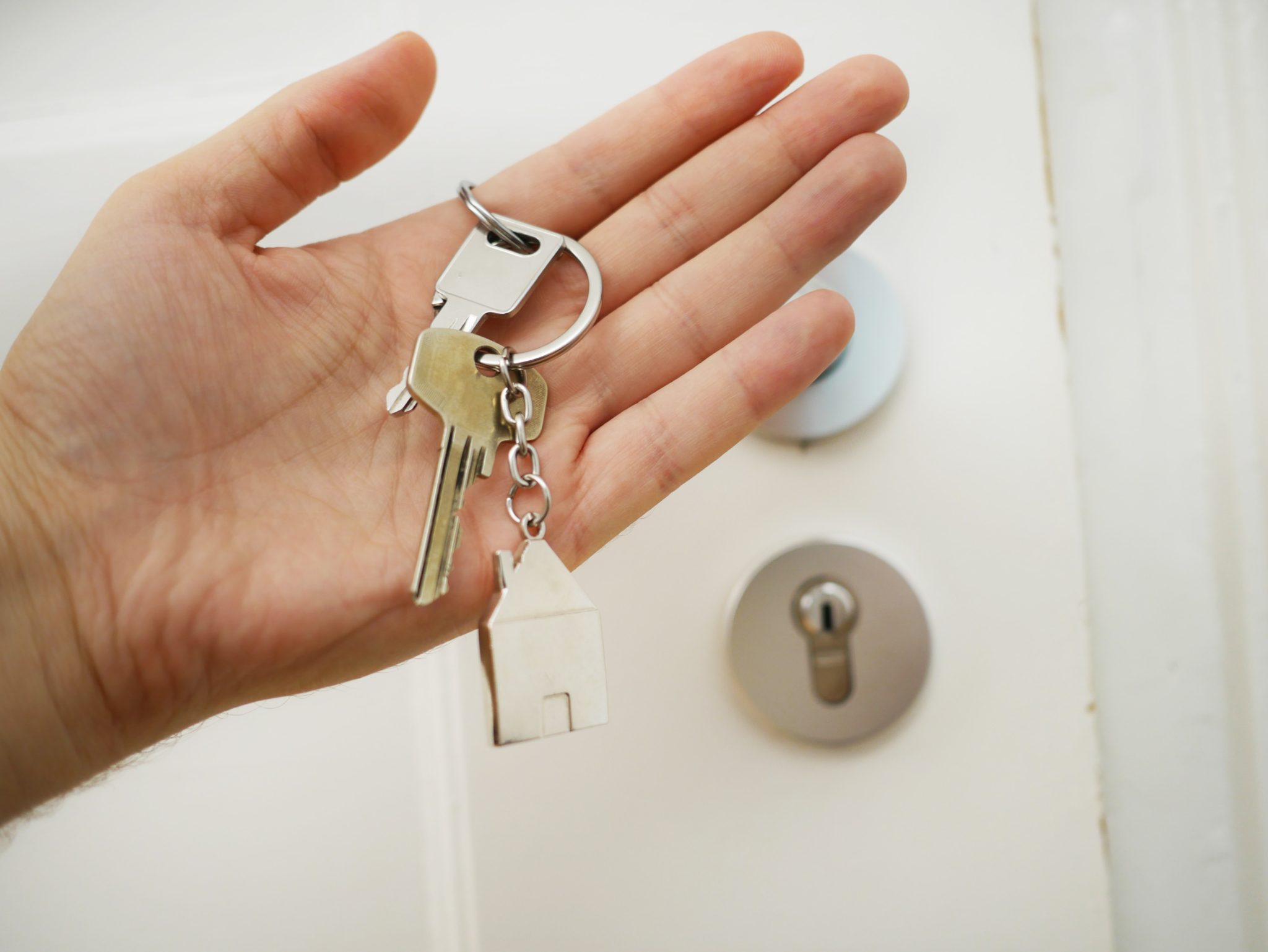 Hand with keys in front of a door