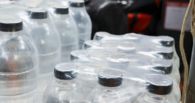 Clear plastic water bottle package wrapped for safe hydration. Bulk pack provides reliable storage for emergency drink supply, giving feeling of secure preparation and essential daily readiness