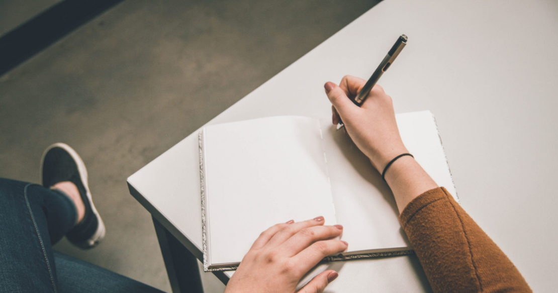 Person writing in book