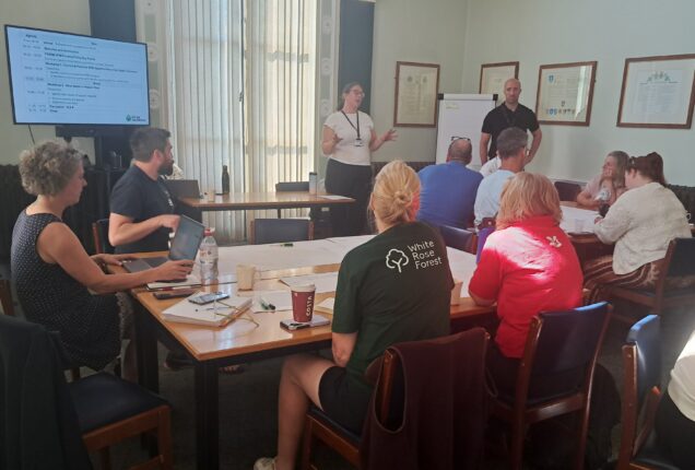 he Calder Catchment NFM Workshop brought local partners together to explore nature-based flood solutions and prepare collaborative funding applications. Meeting at Town Hall in Halifax shows partners sat at tables and a presenter.