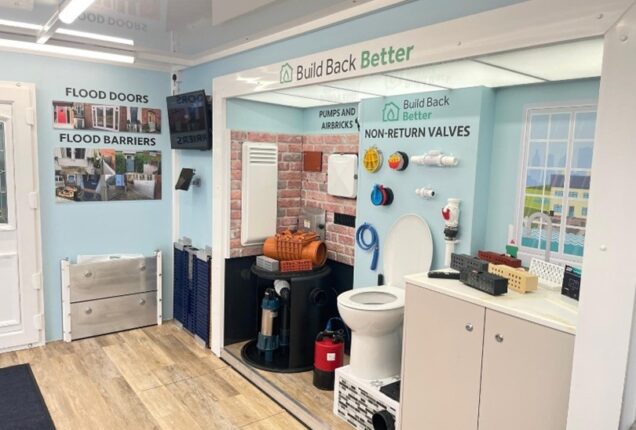 Interior view of the Flood Pod demonstration unit displaying various household flood protection products and equipment.